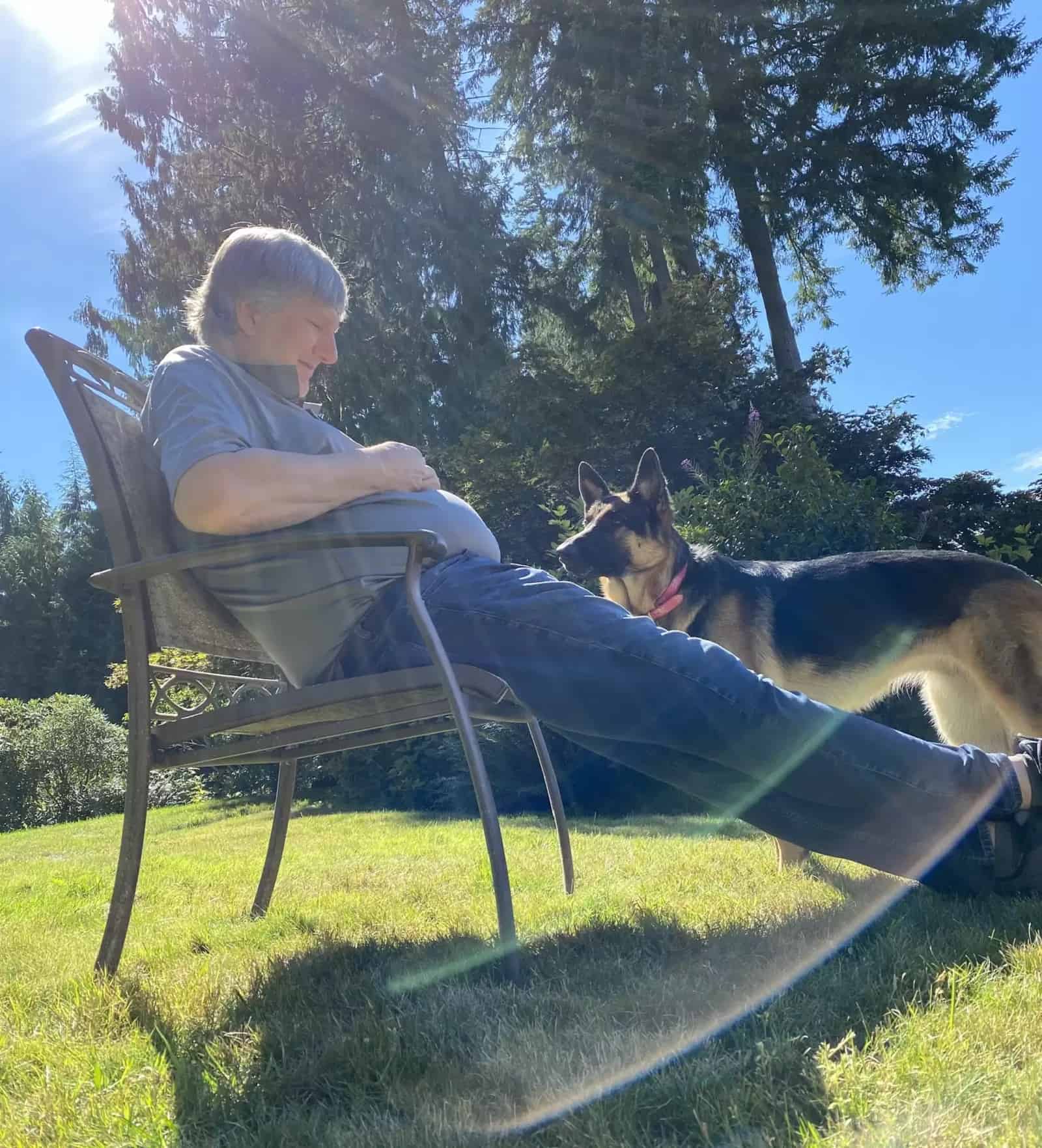 owner with his german shepherd dog enjoying in garden