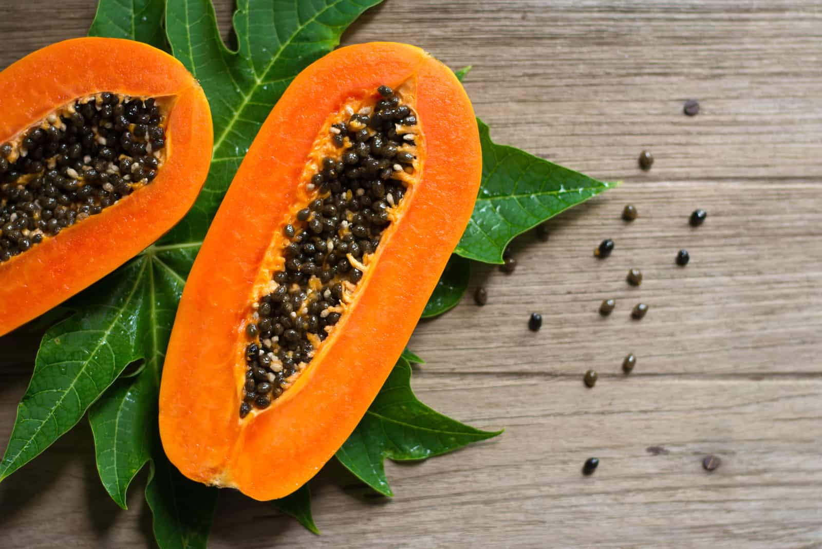 Slices of sweet papaya fruit on wooden background