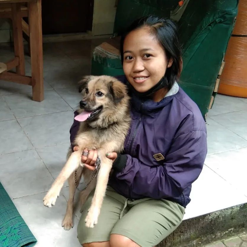 photo of a woman holding the dog