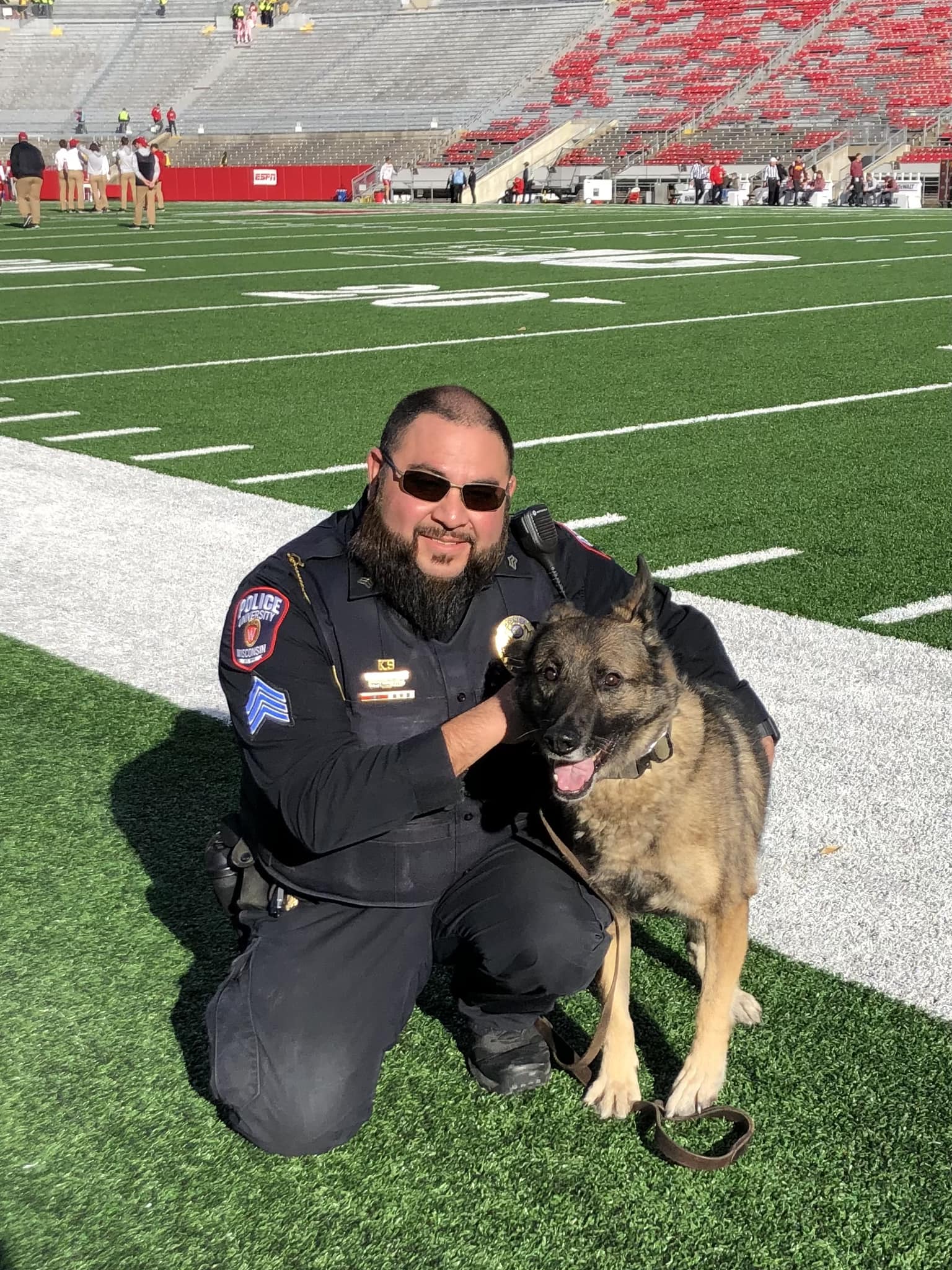 police officer and dog maya at a football field