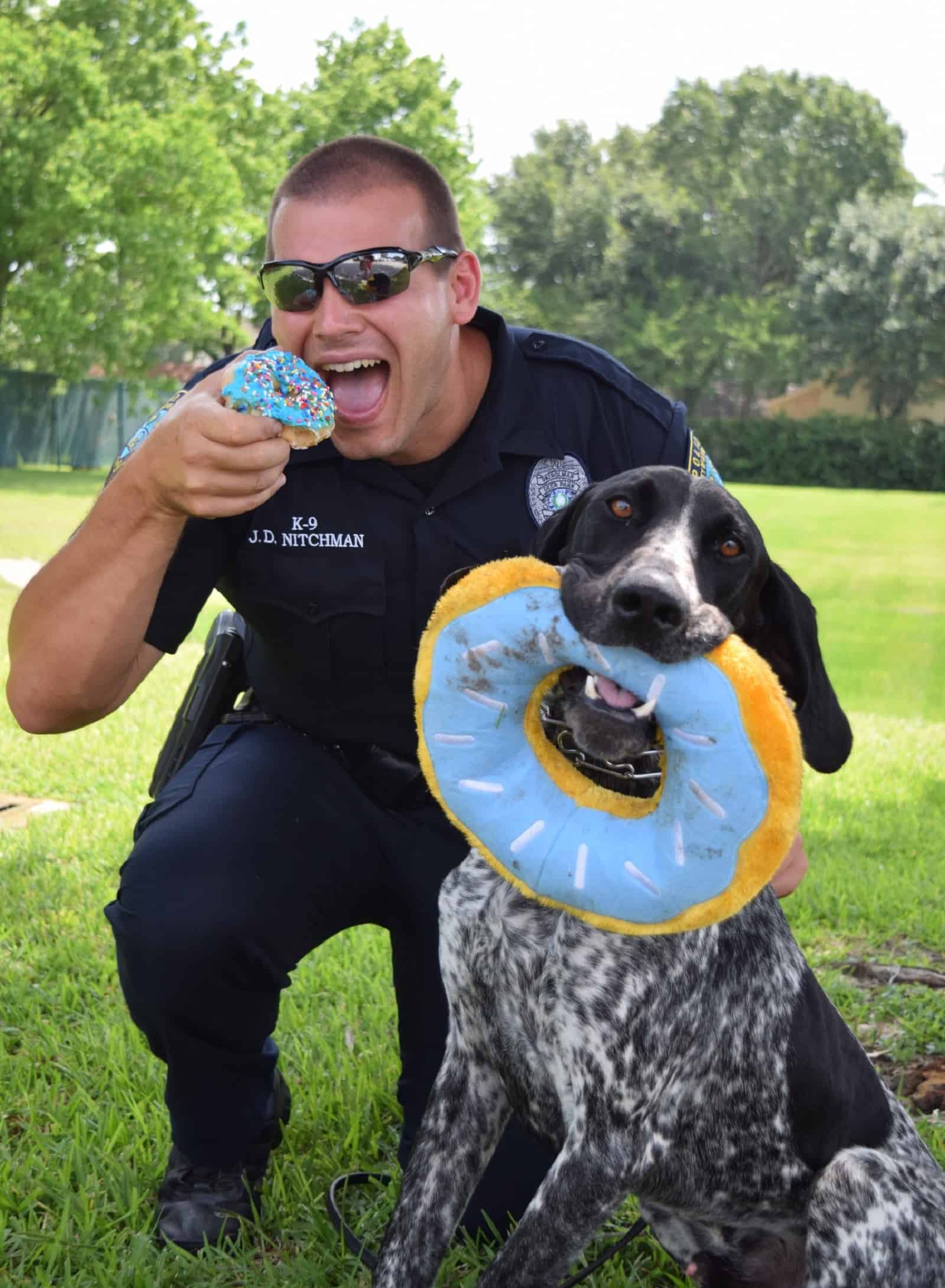 police officer and his K9 partner eating doughnuts