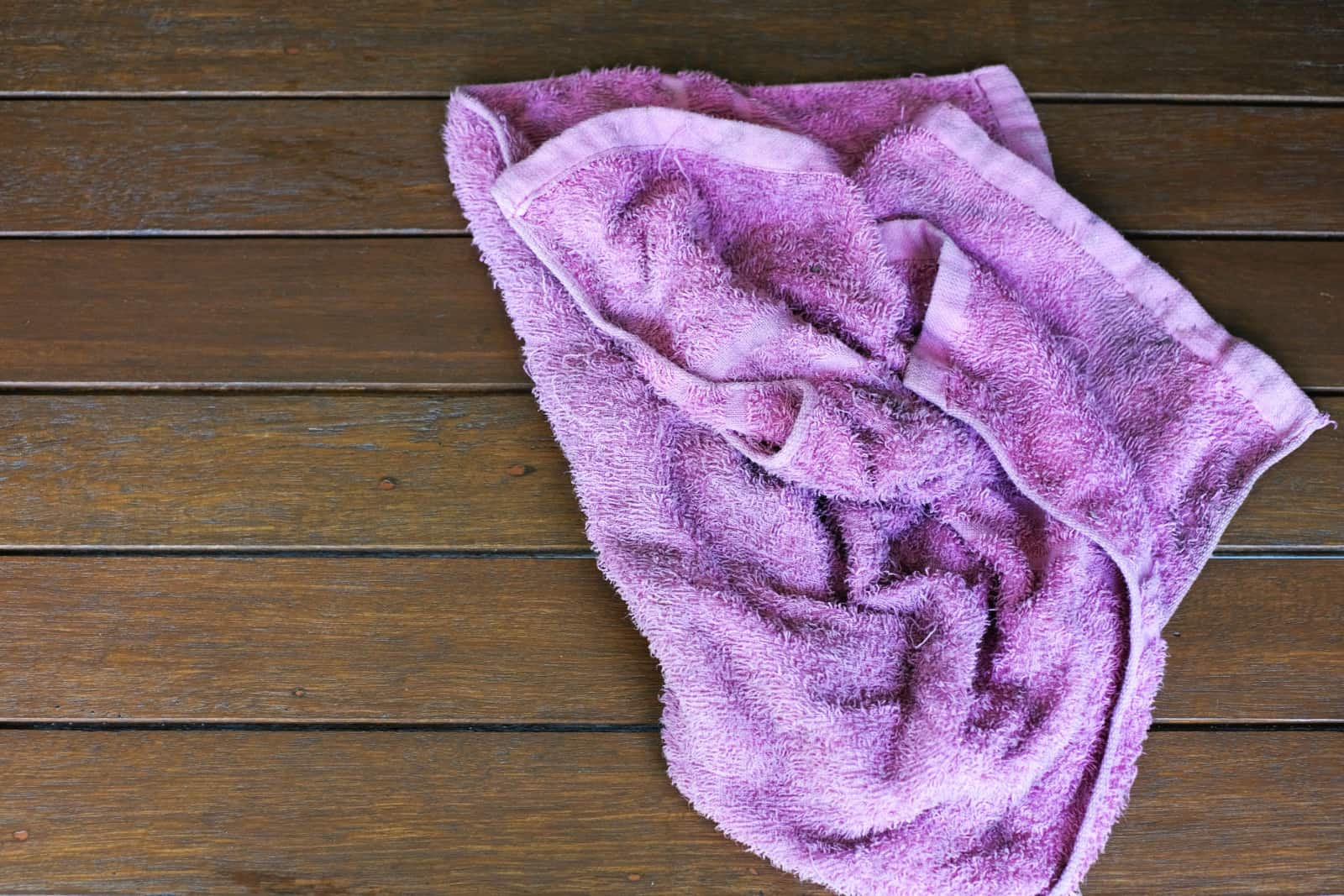 purple rag isolated on wooden background