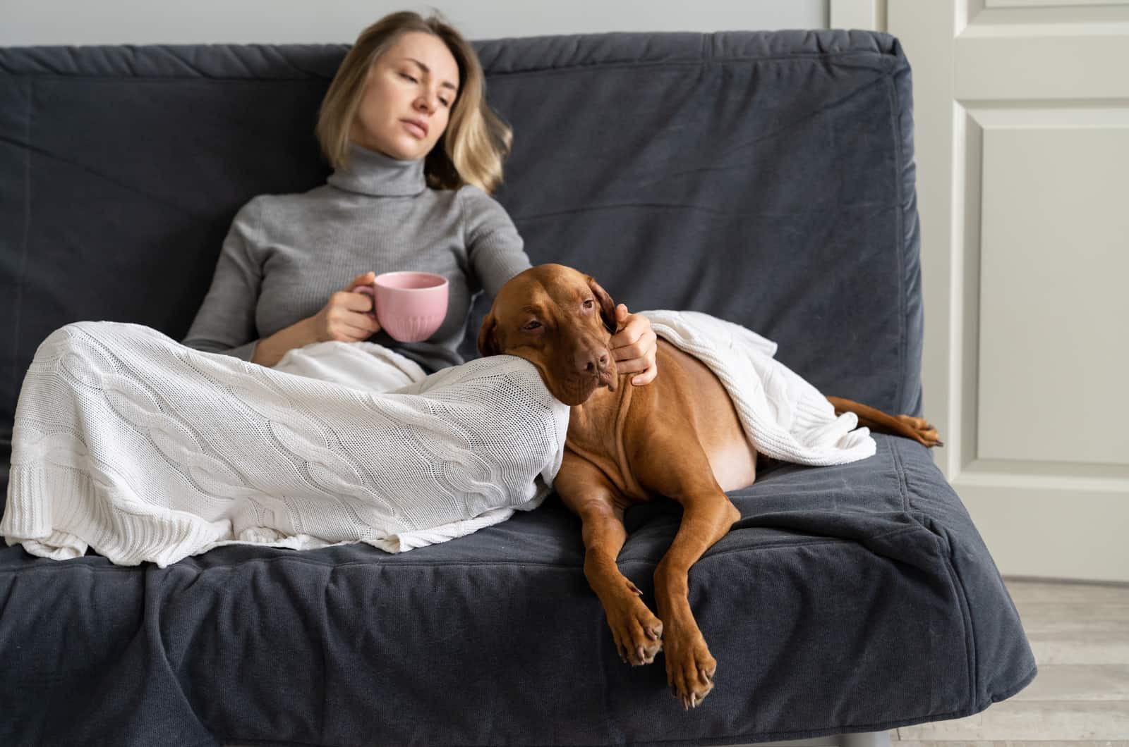 sad woman and dog sitting on couch