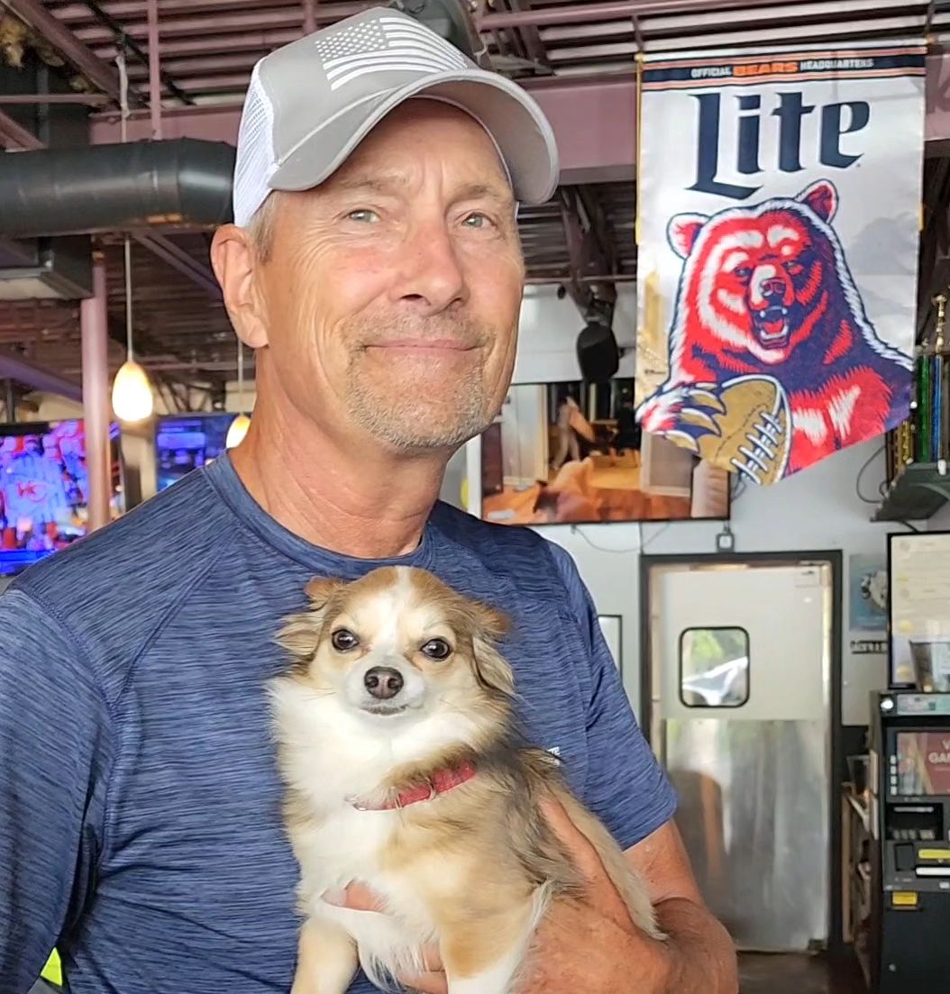 smiling man with chihuahua in lap