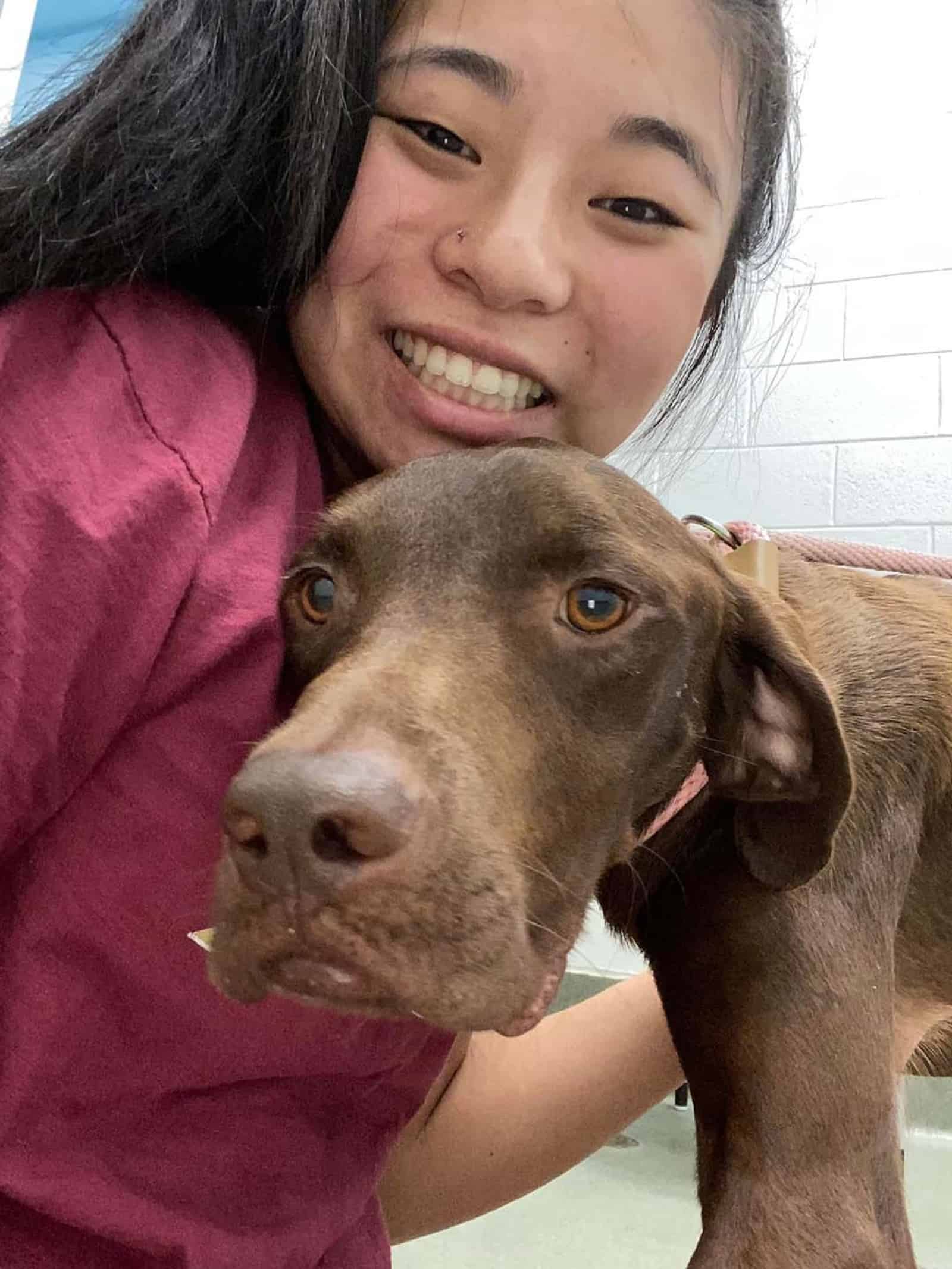 smiling woman and brown dog cuddling