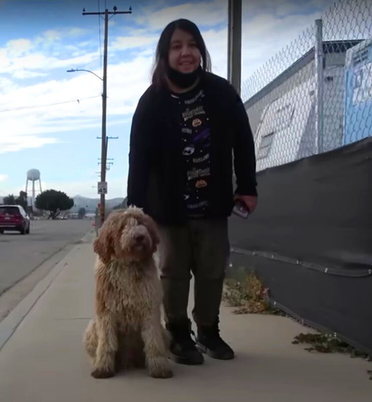 smiling woman posing with dog outdoor