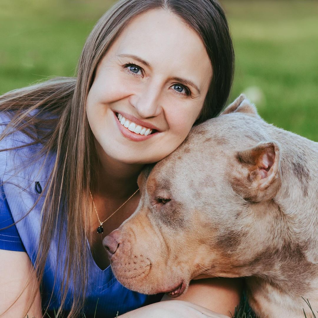 smiling woman posing with dog