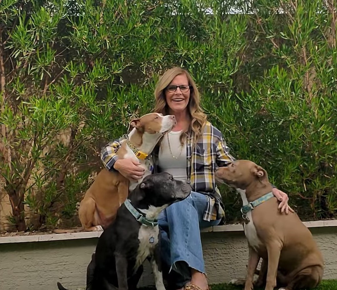 smiling woman with dogs sitting