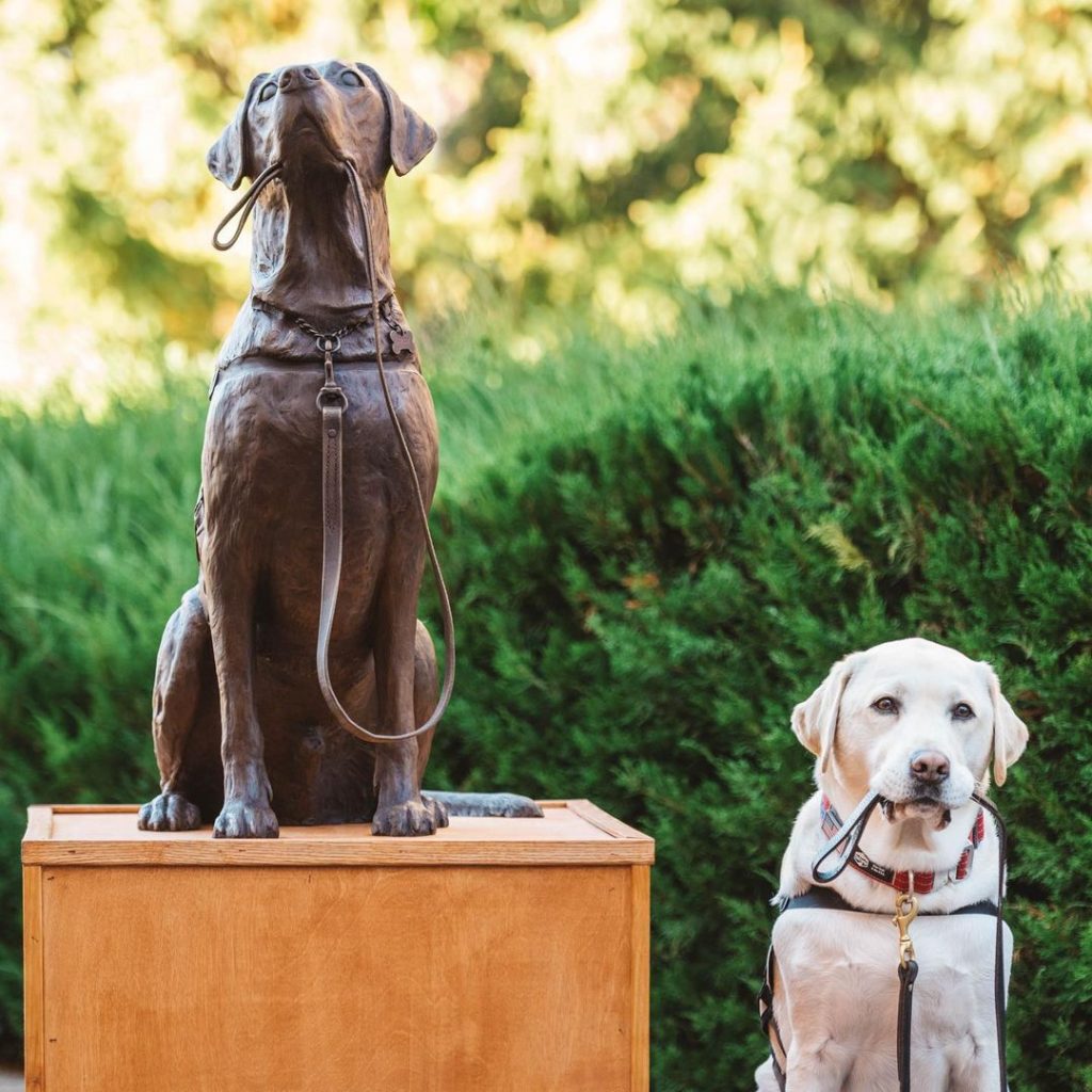 sully standing next to his bronze statue