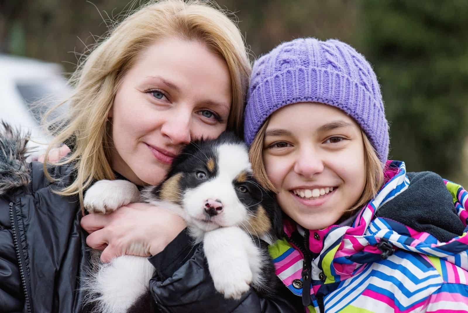 teenage girl and mom playing with puppy