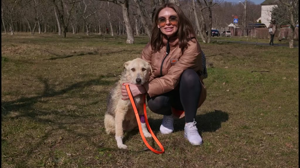 the girl takes a picture with the dog she saved