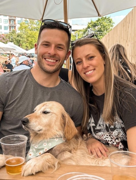 the golden retriever enjoys the lap of a man and a woman