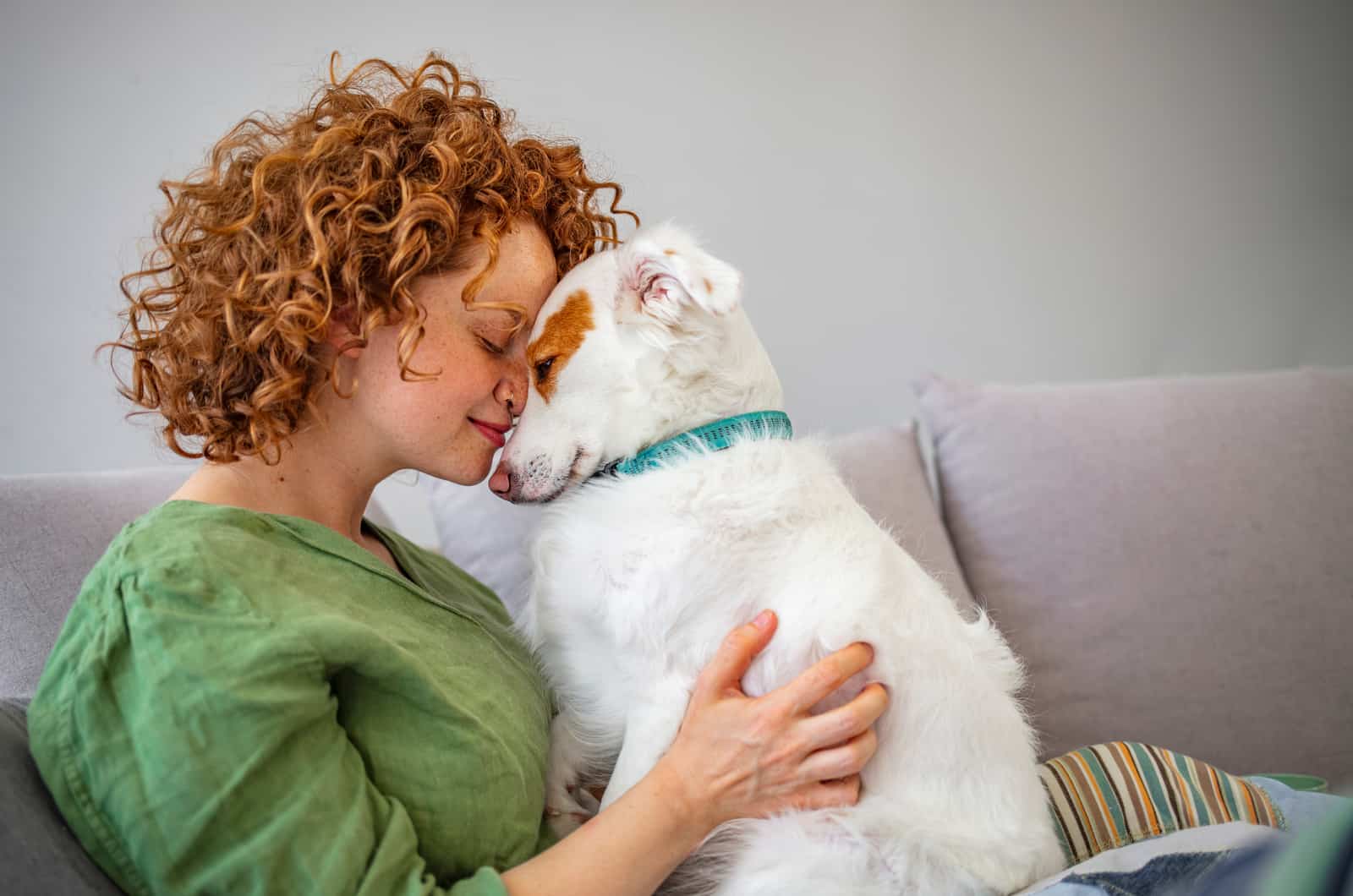 woman and her dog touching heads