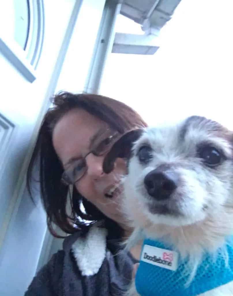 a smiling woman holding her rescue dog