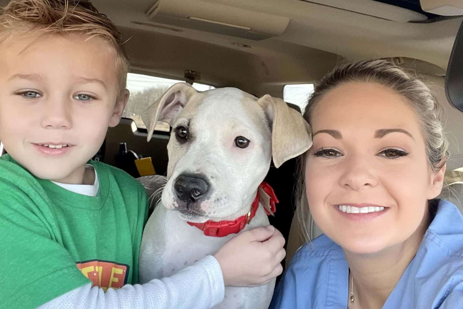 woman and her son posing with dog