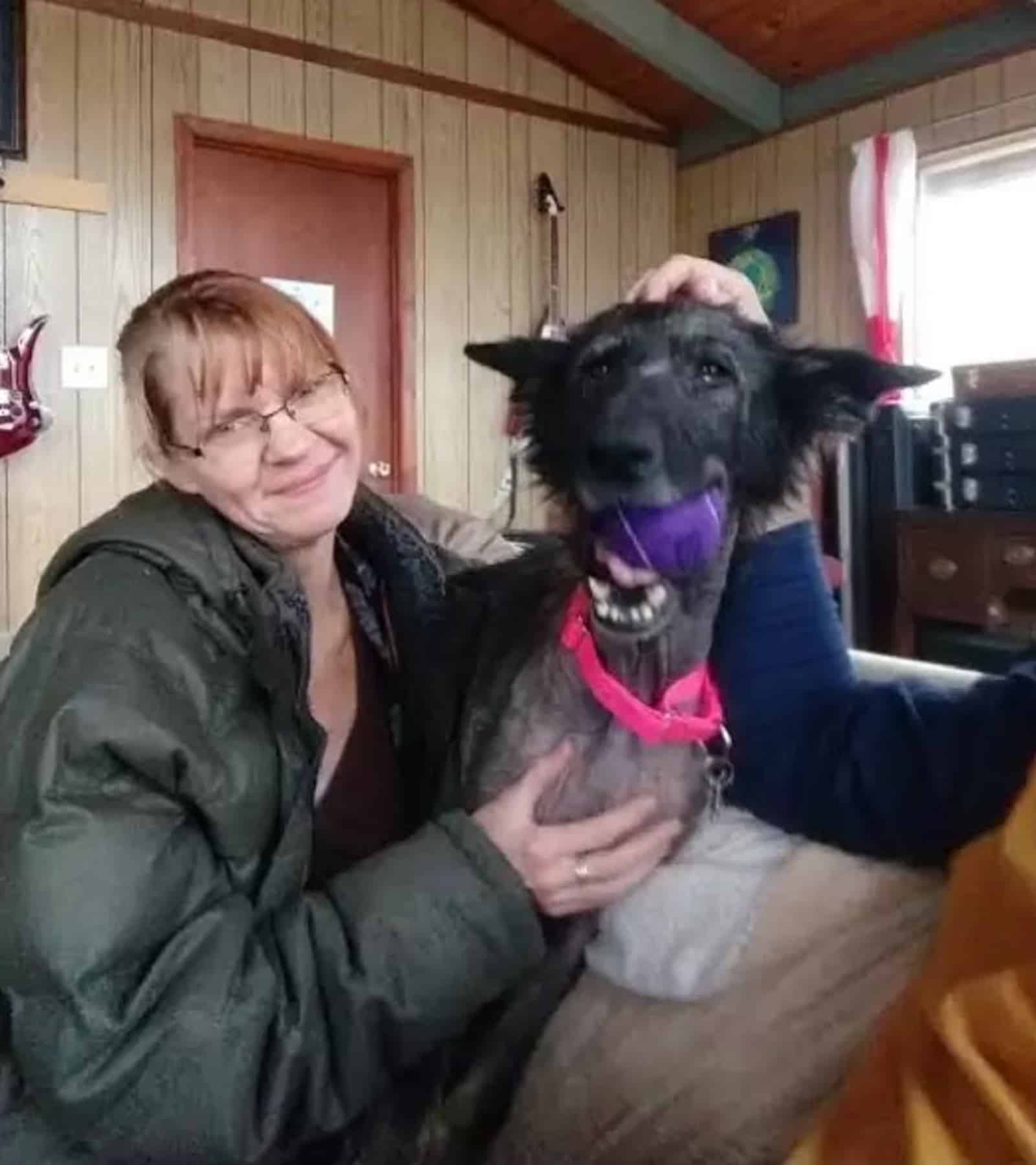 woman cuddling german shepherd dog at home