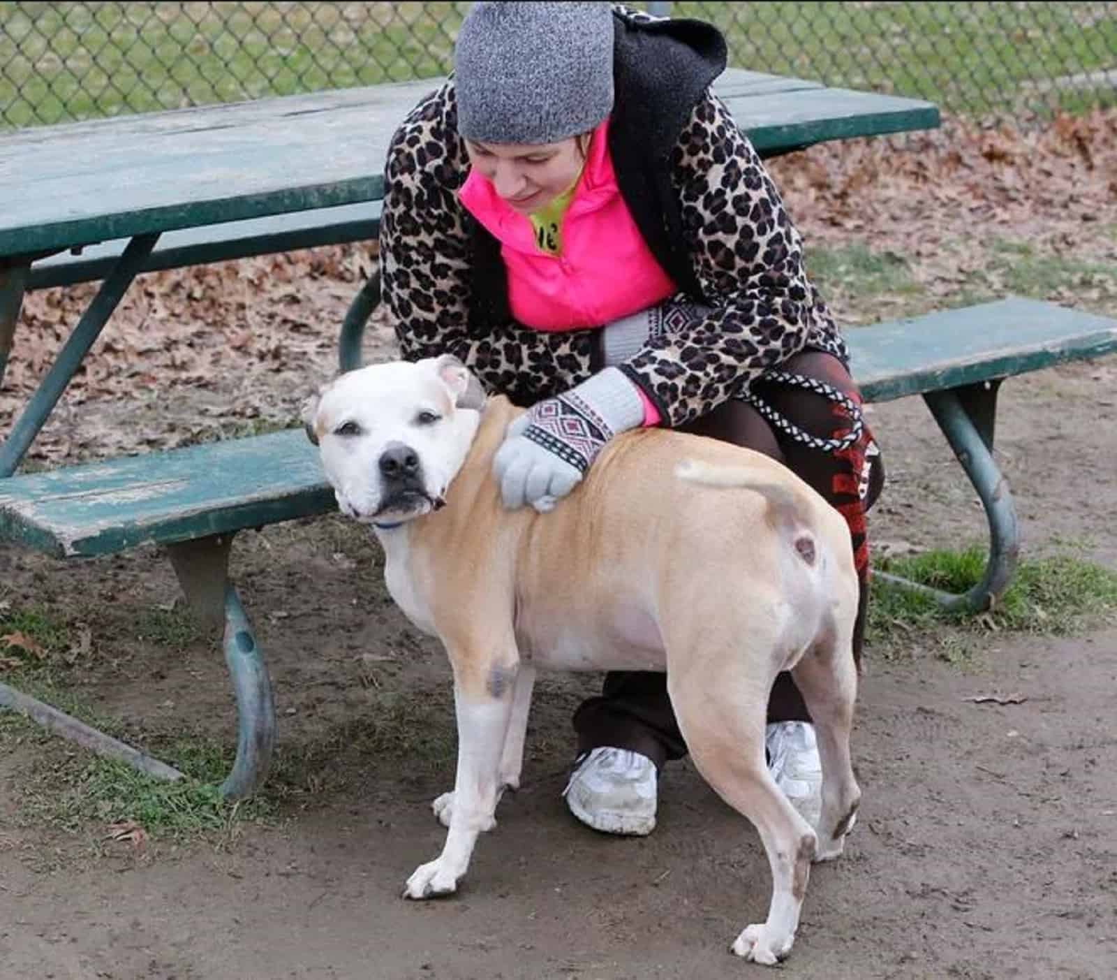 woman cuddling her dog in the park
