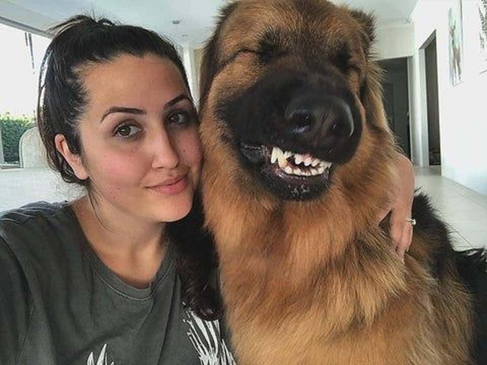 woman embracing her happy german shepherd dog