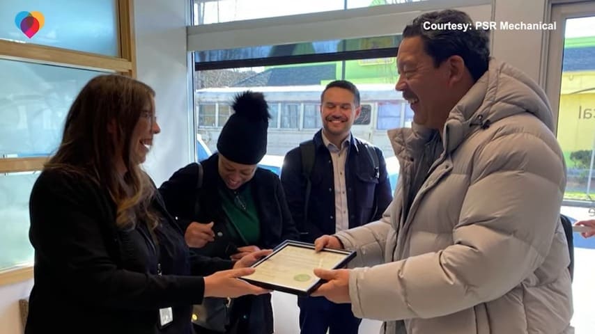 woman giving letter of recognition to a man who rescued dogs