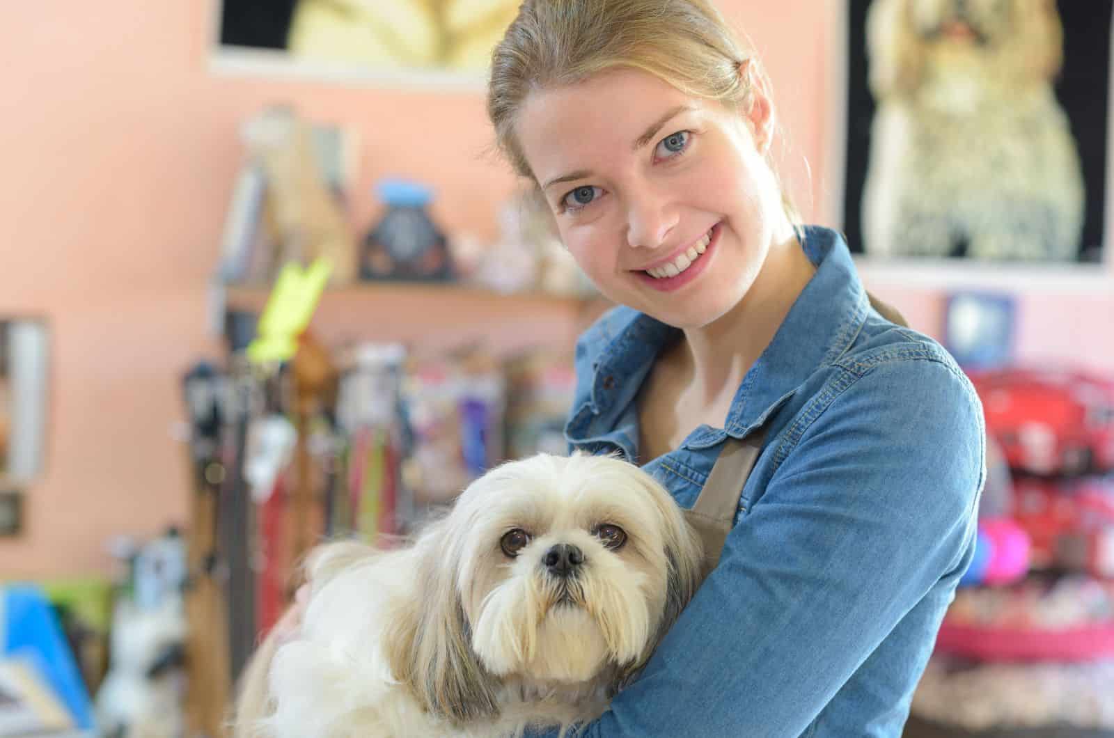 woman holding her white dog in store