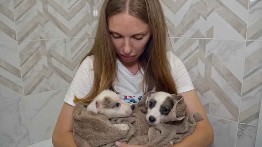 woman holding puppies in arms