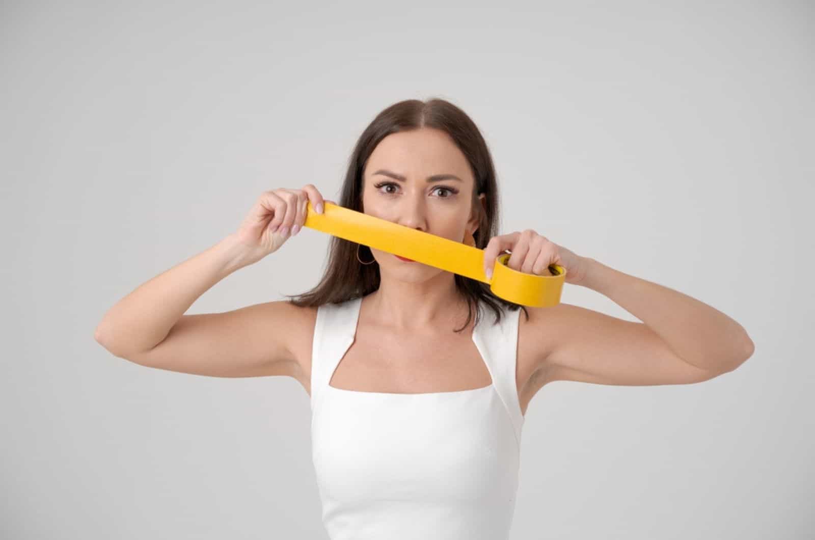 woman holding sticky tape in front of her face