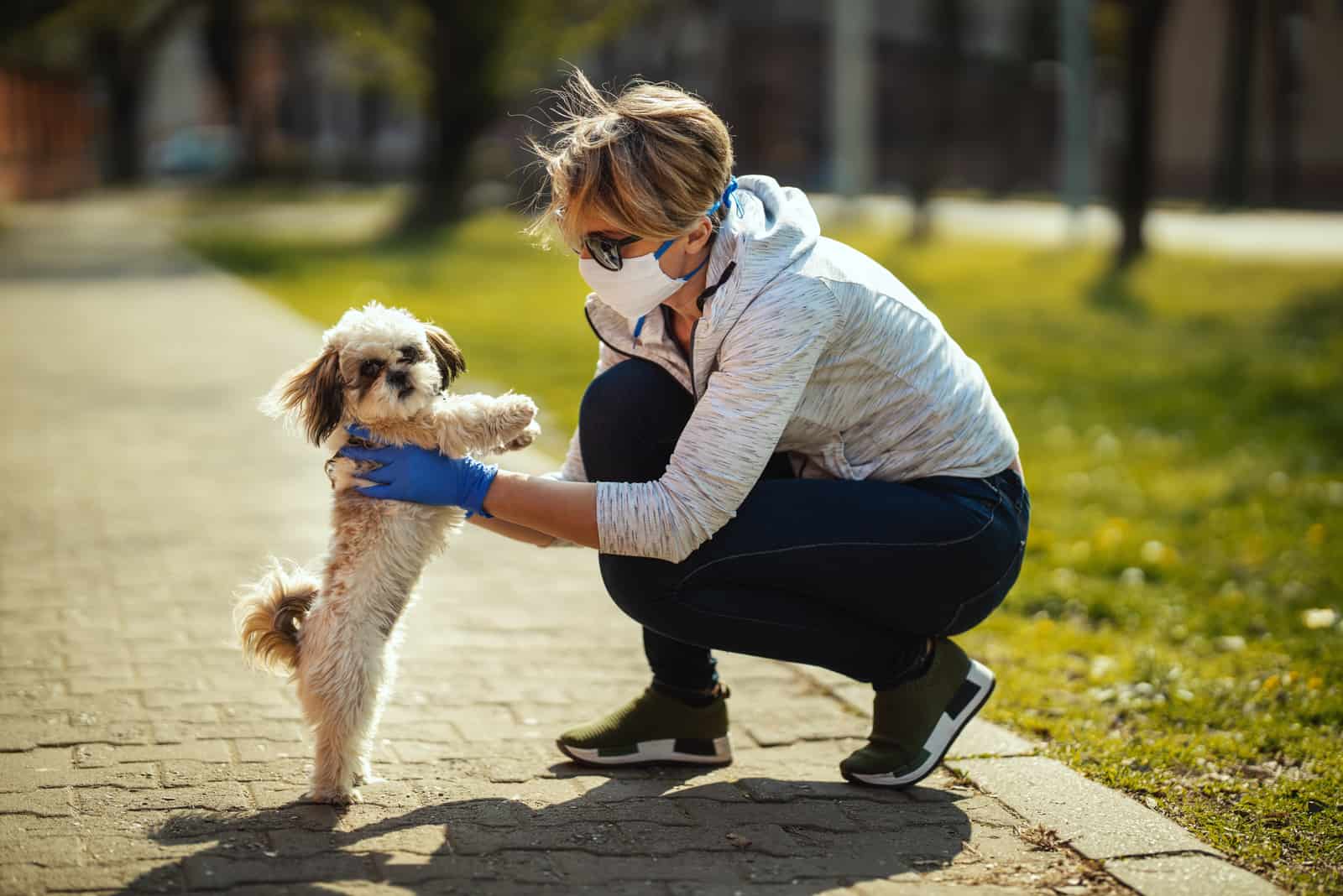 woman in a park holding her dog