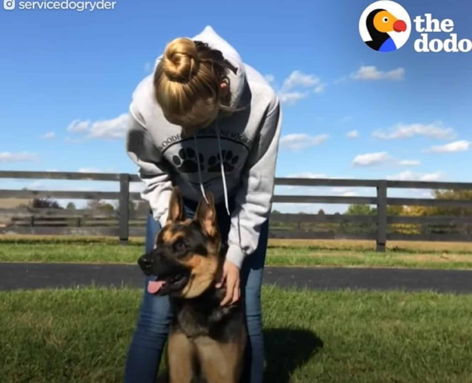 woman playing with german shepherd dog outdoors