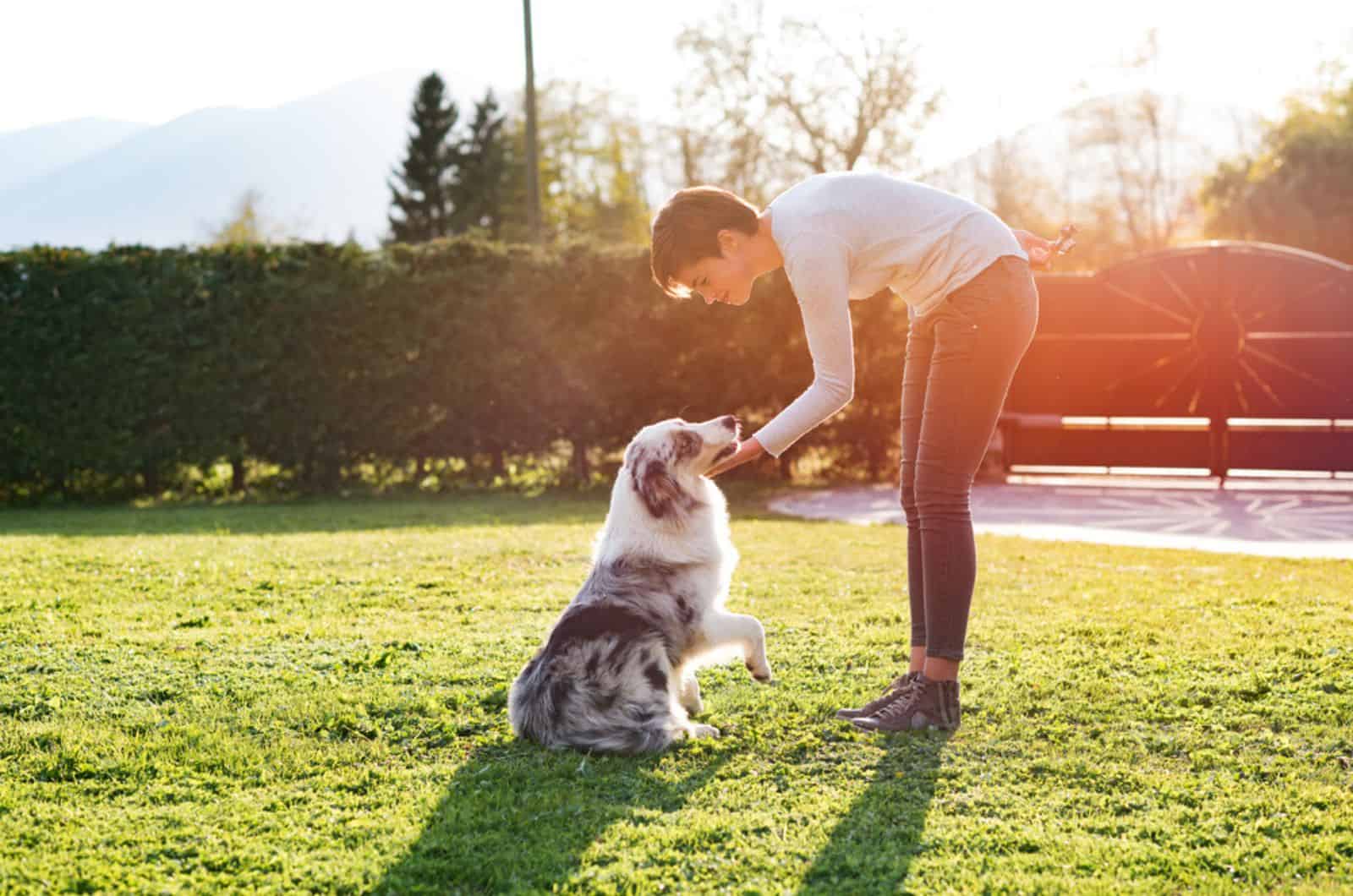 woman playing with her dog in the garden