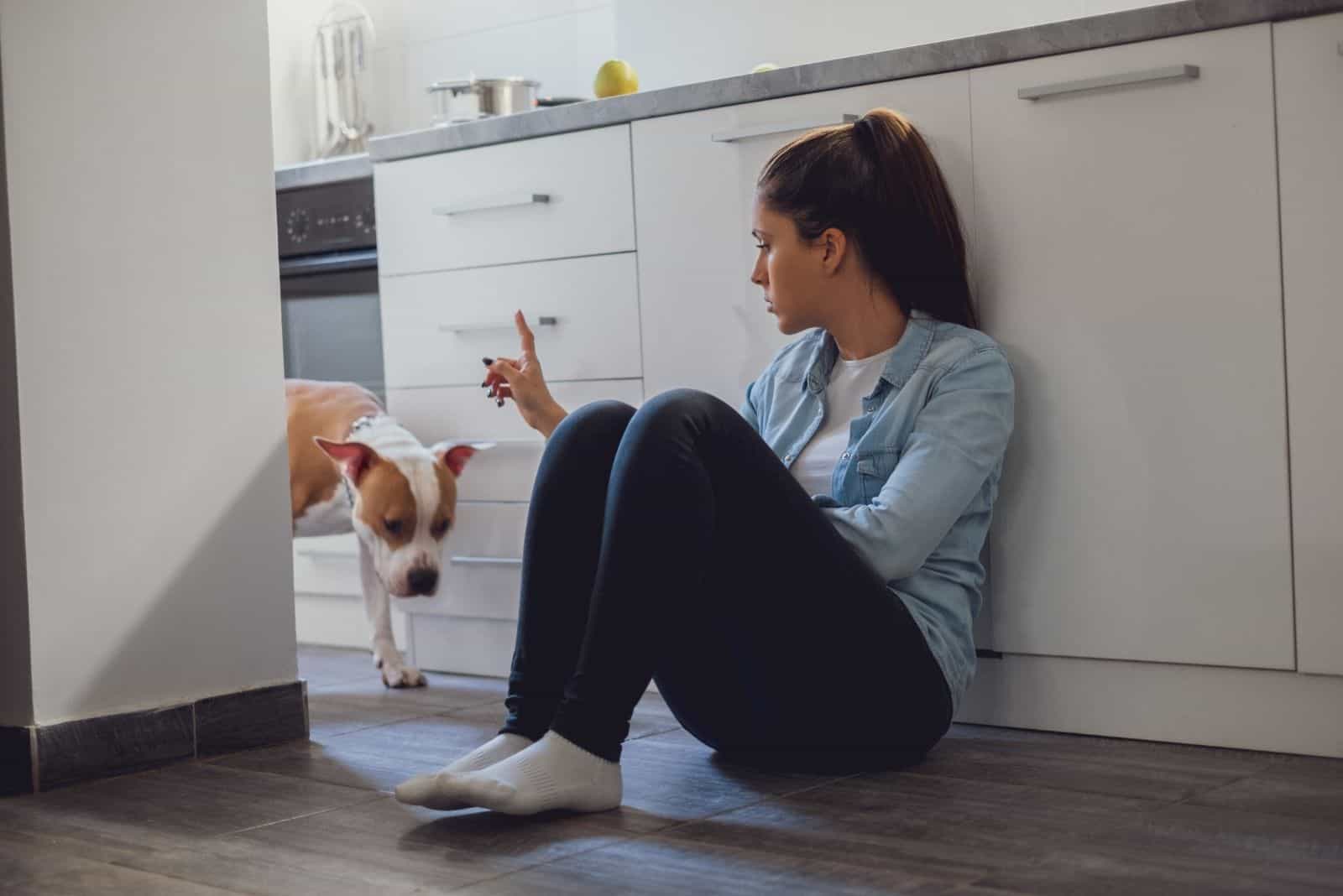 woman scolding dog in the kitchen