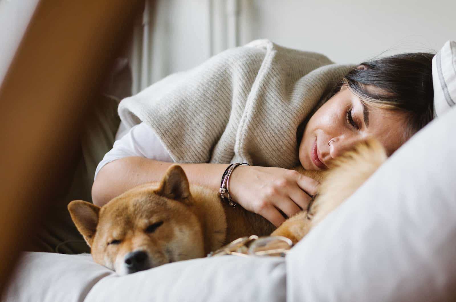 woman sleeping next to shiba inu