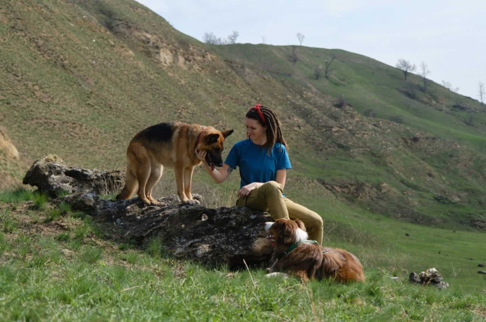 woman stroking german shepherd dog in nature