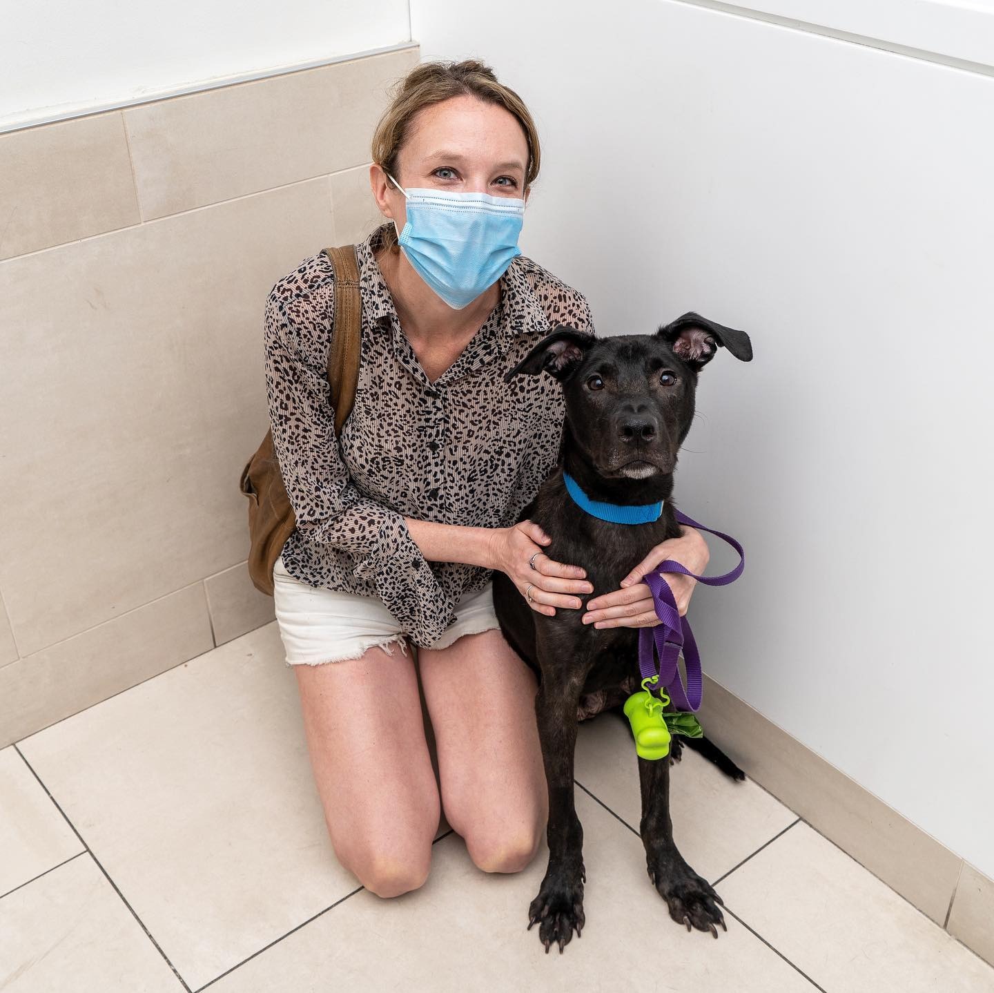 Woman with mask and skinny dog