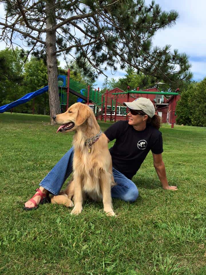 woman with retriever on grass