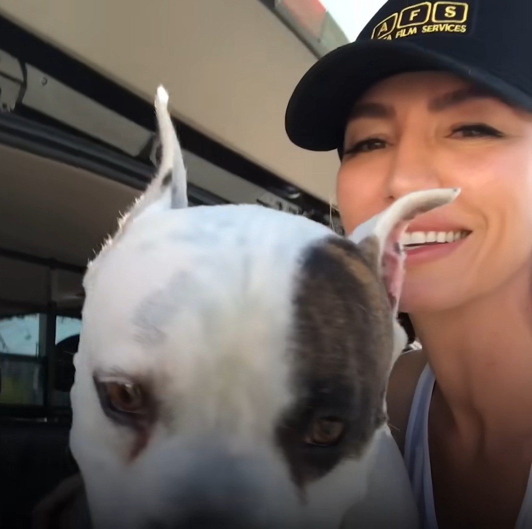 smiling woman taking picture with dog