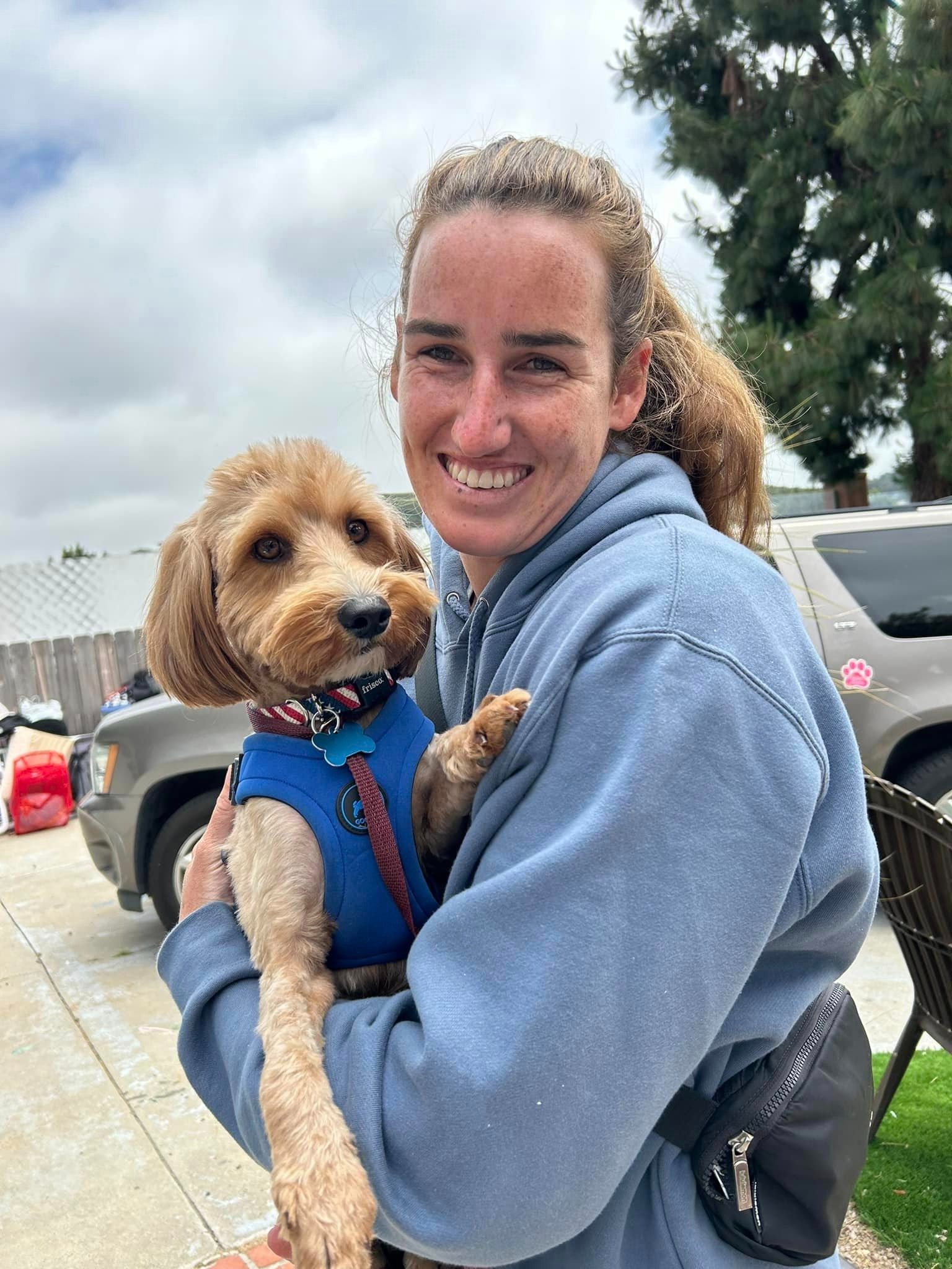 smiling woman with dog in arms