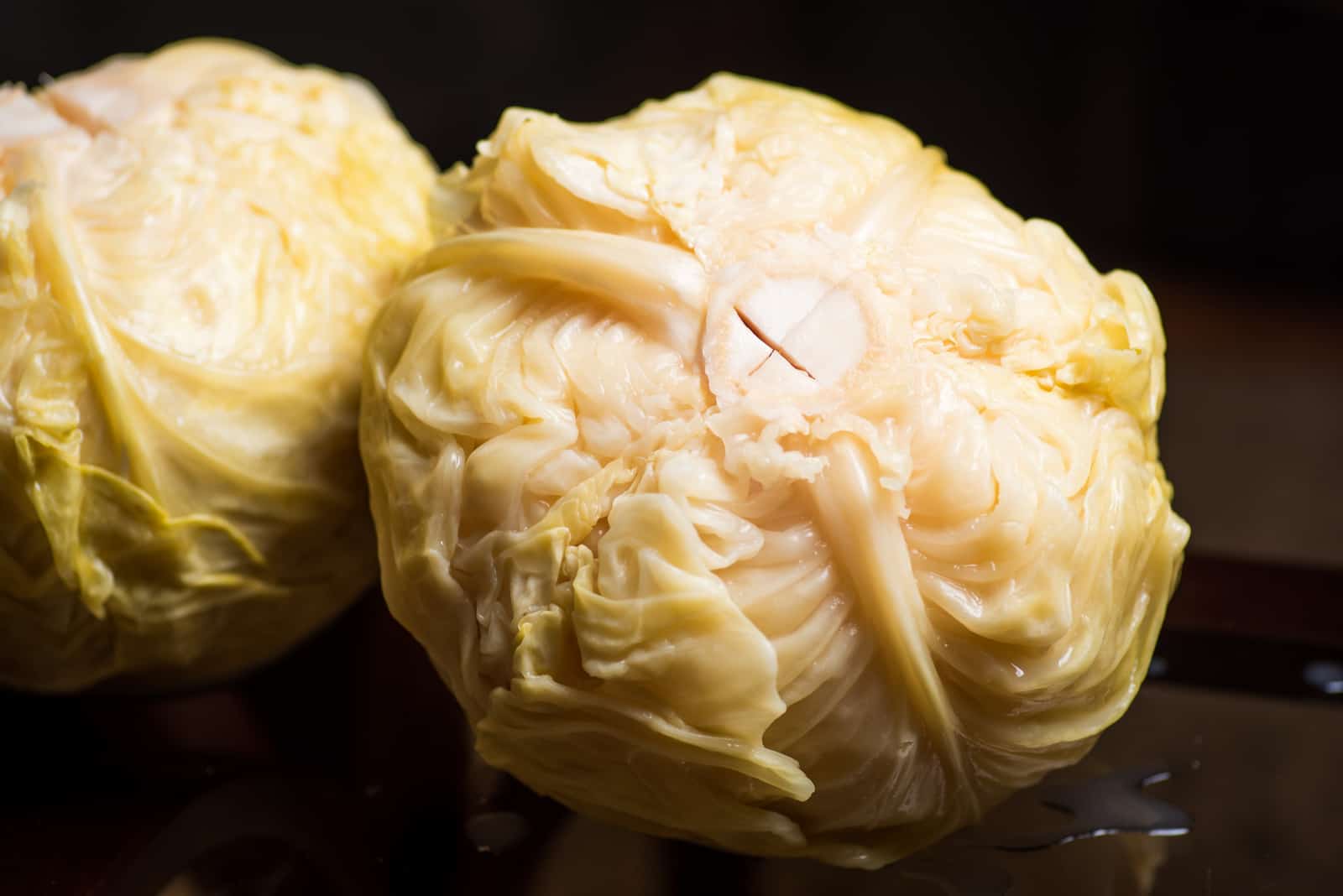 two pieces of sauerkraut stand on a black background