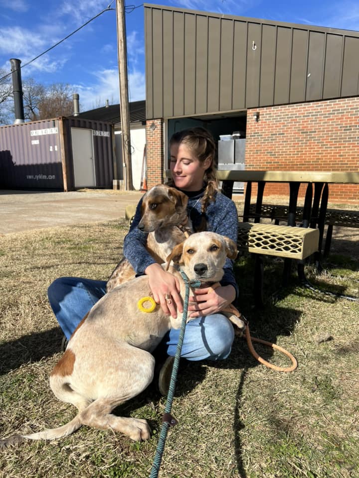 woman holding two dogs