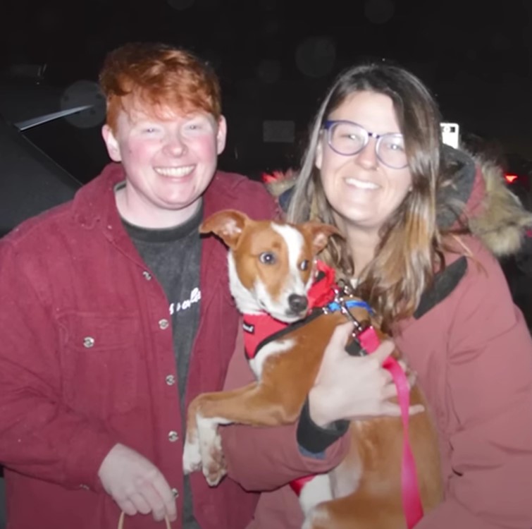 a man and a woman holding a dog