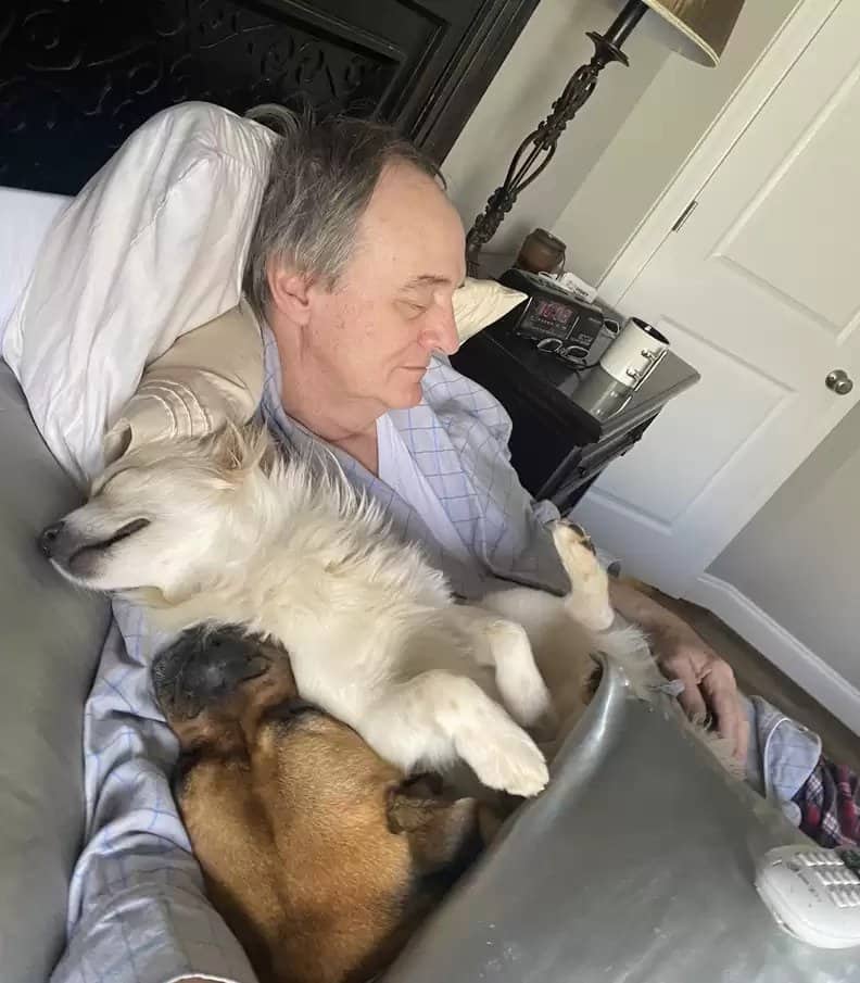 Dad taking a nap with neighbors dog