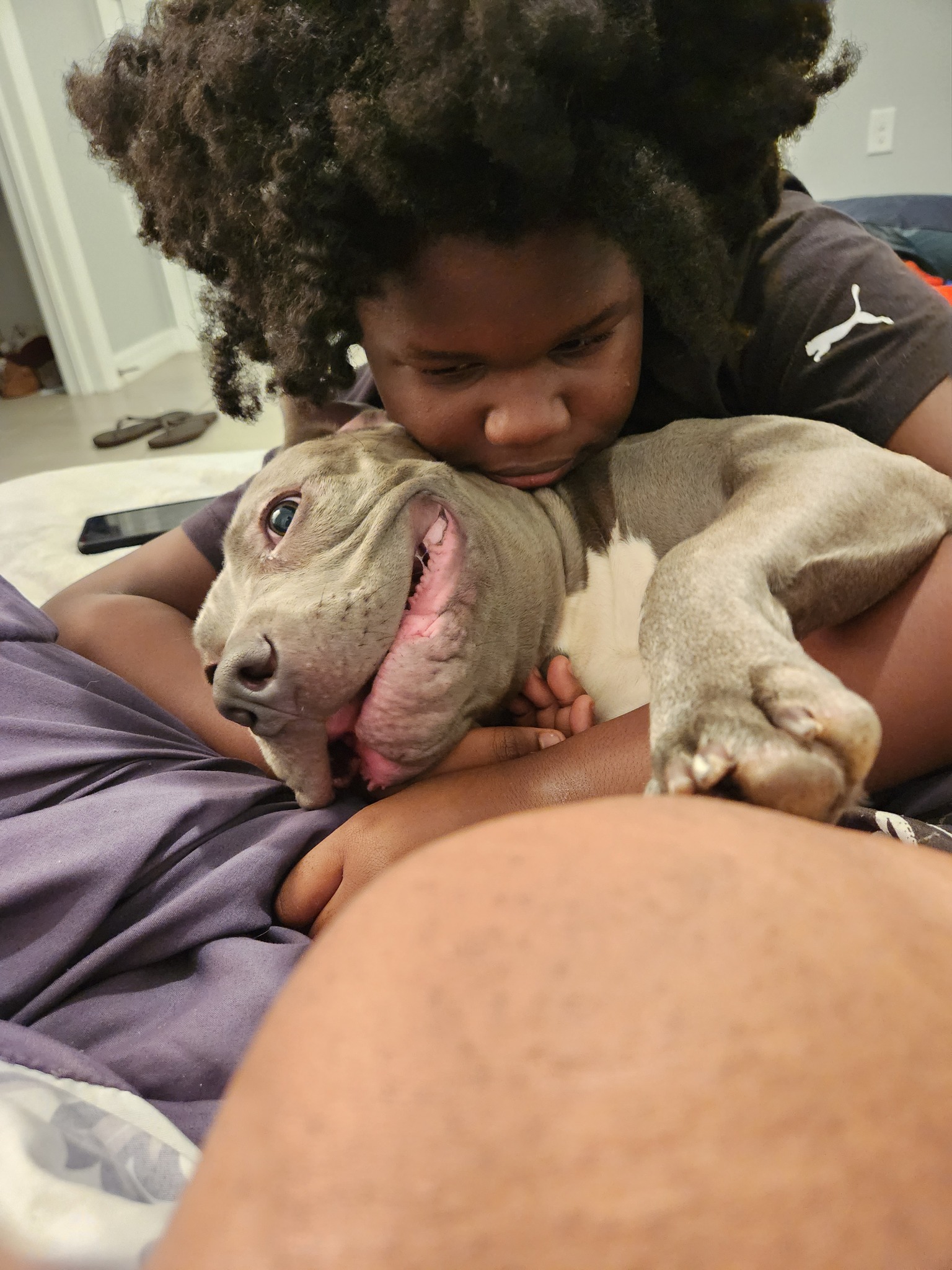 little curly-haired boy hugging her dog