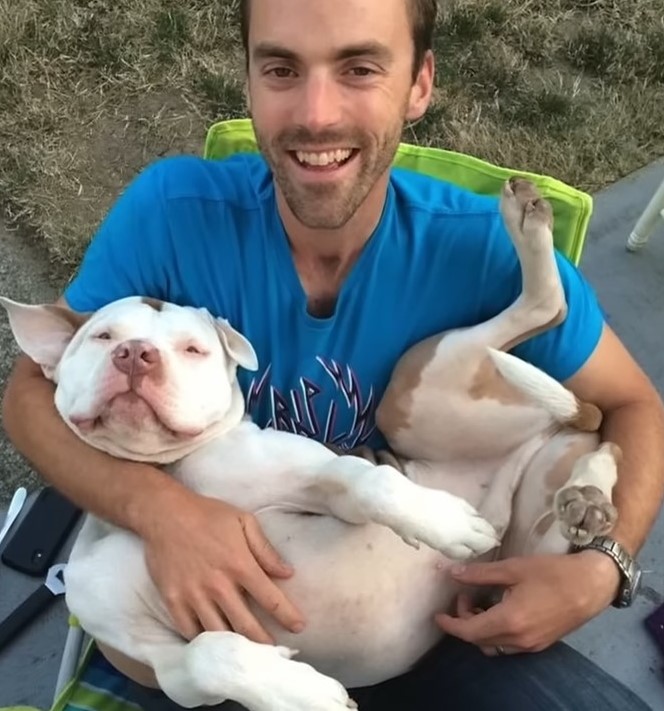 a man holds a dog in his arms