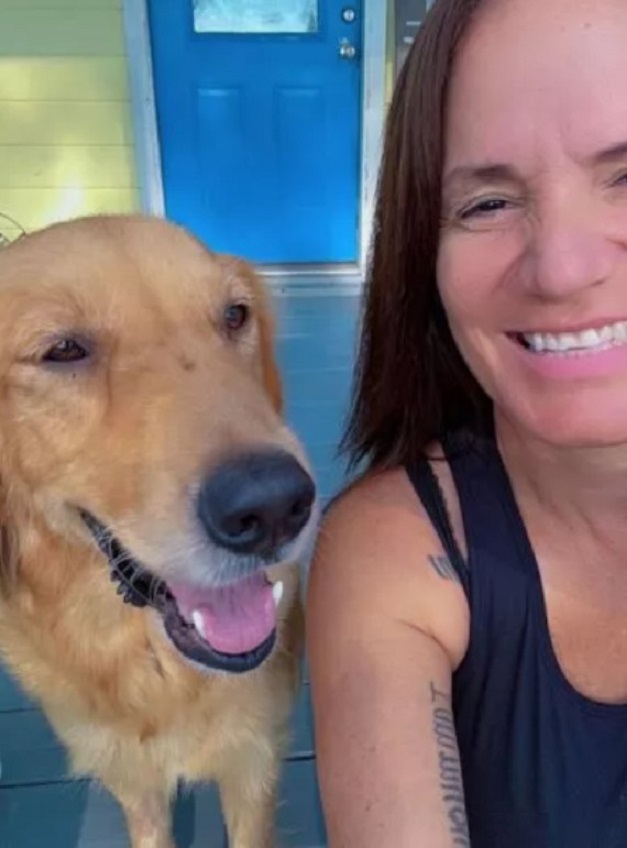 a woman takes a picture with a golden retriever