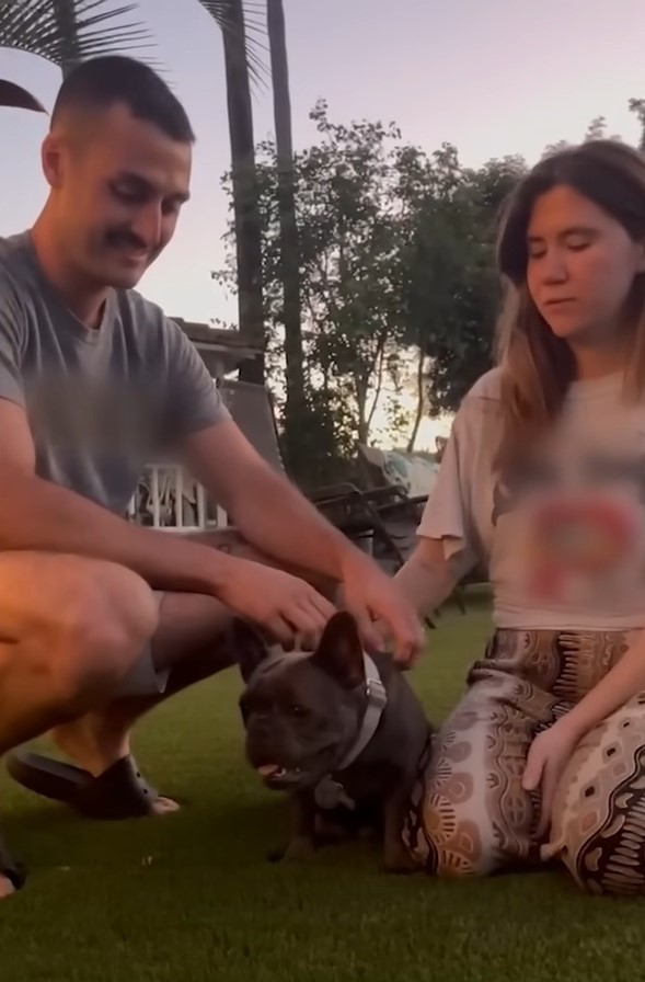 a young loving couple petting a dog