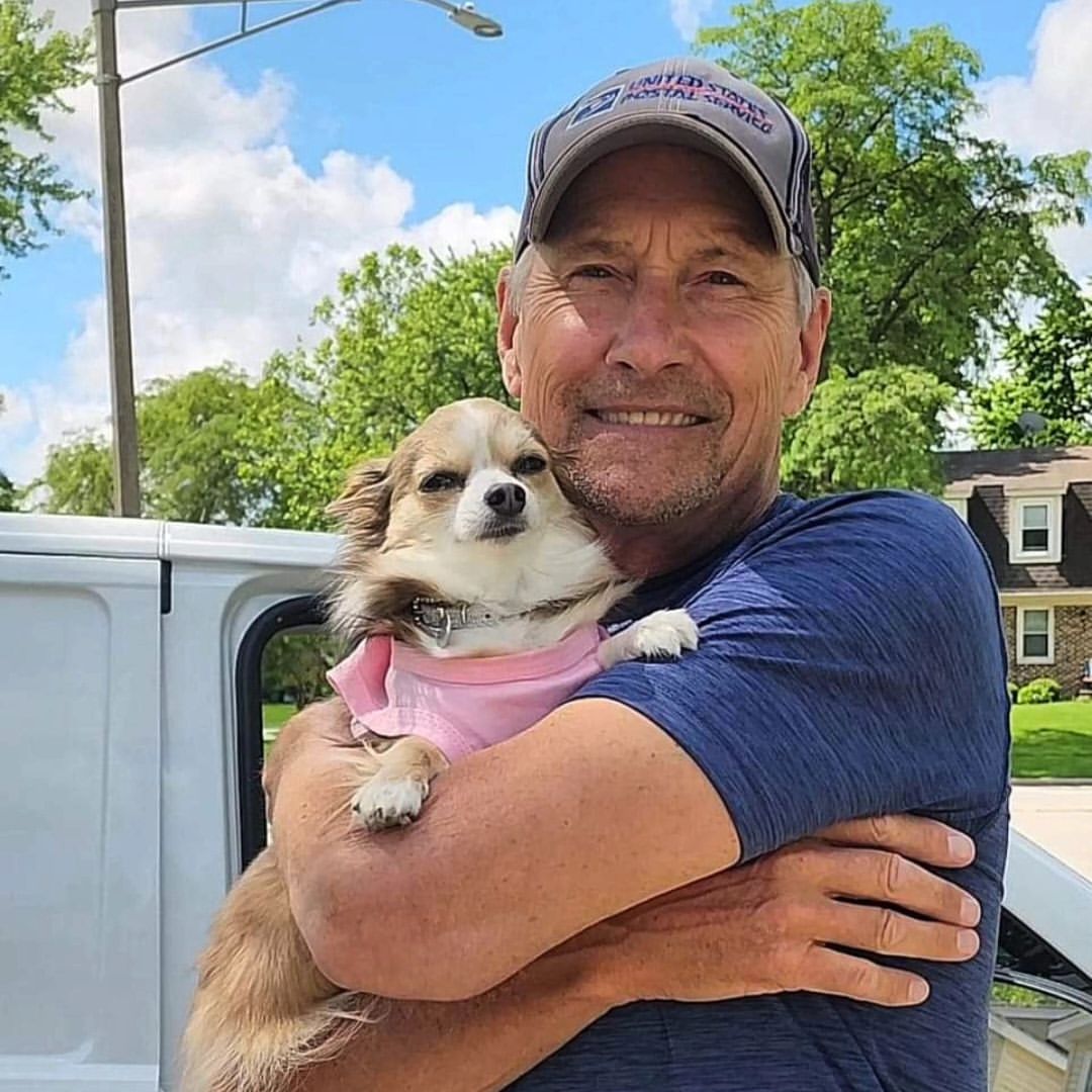 man hugging a chihuahua