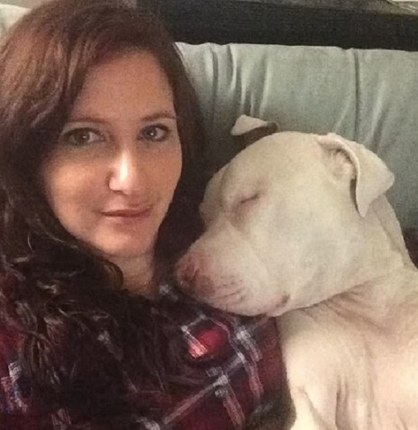 the dog sleeps on the woman's shoulder