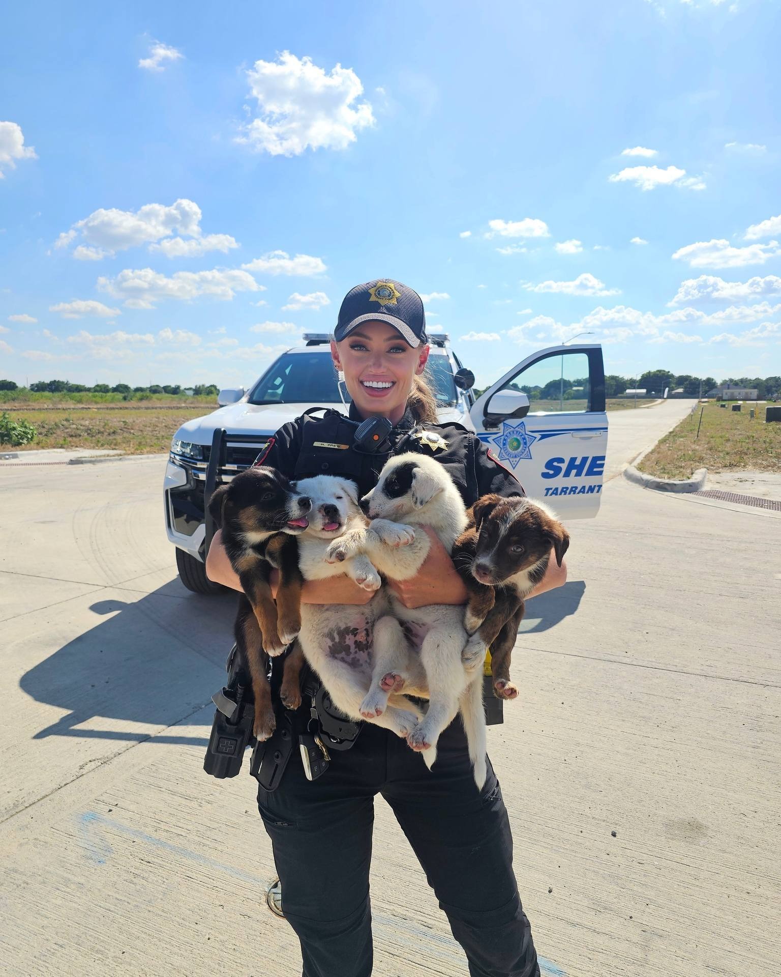 woman police officer holding puppies